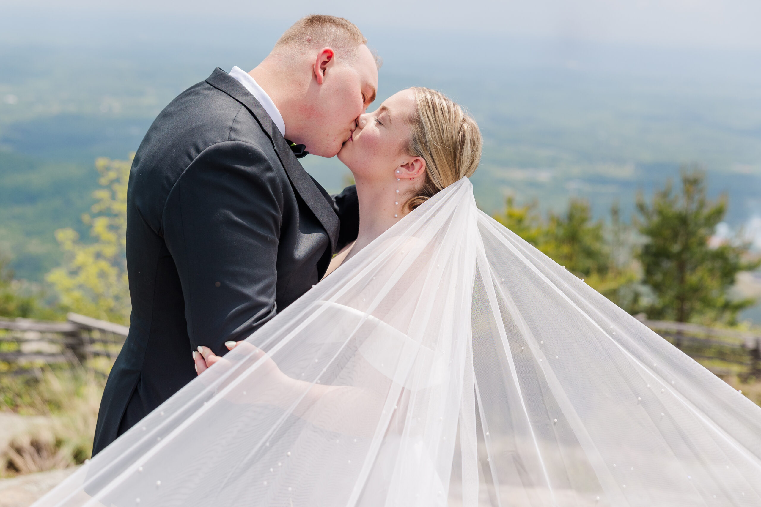 husband and wife kissing at the cliffs at glassy mountain