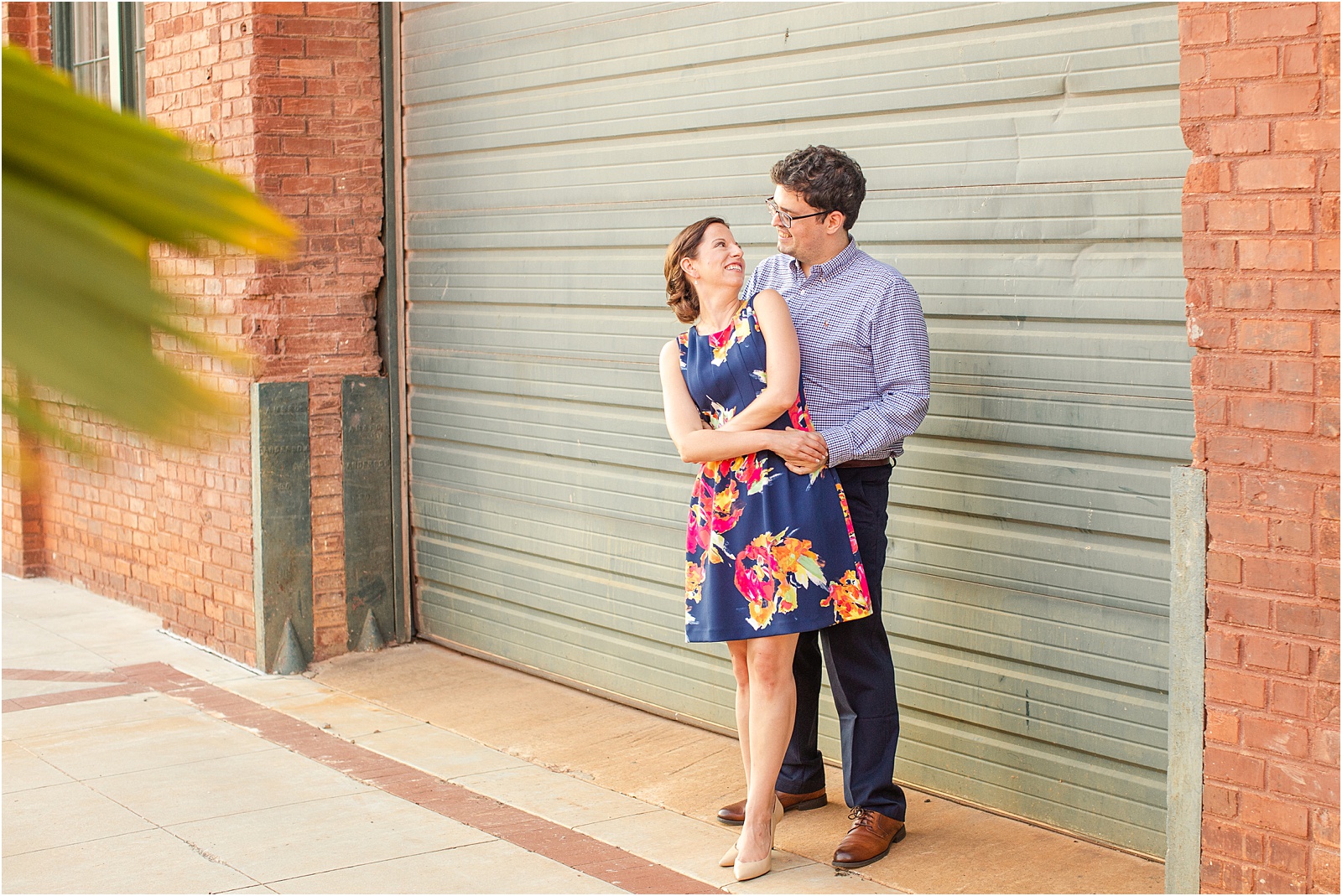 engagements pictures of a man and woman standing in front of a green garage door in anderson sc
