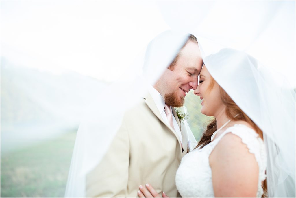 A bride and groom under the veil nose to nose in Greenville, SC