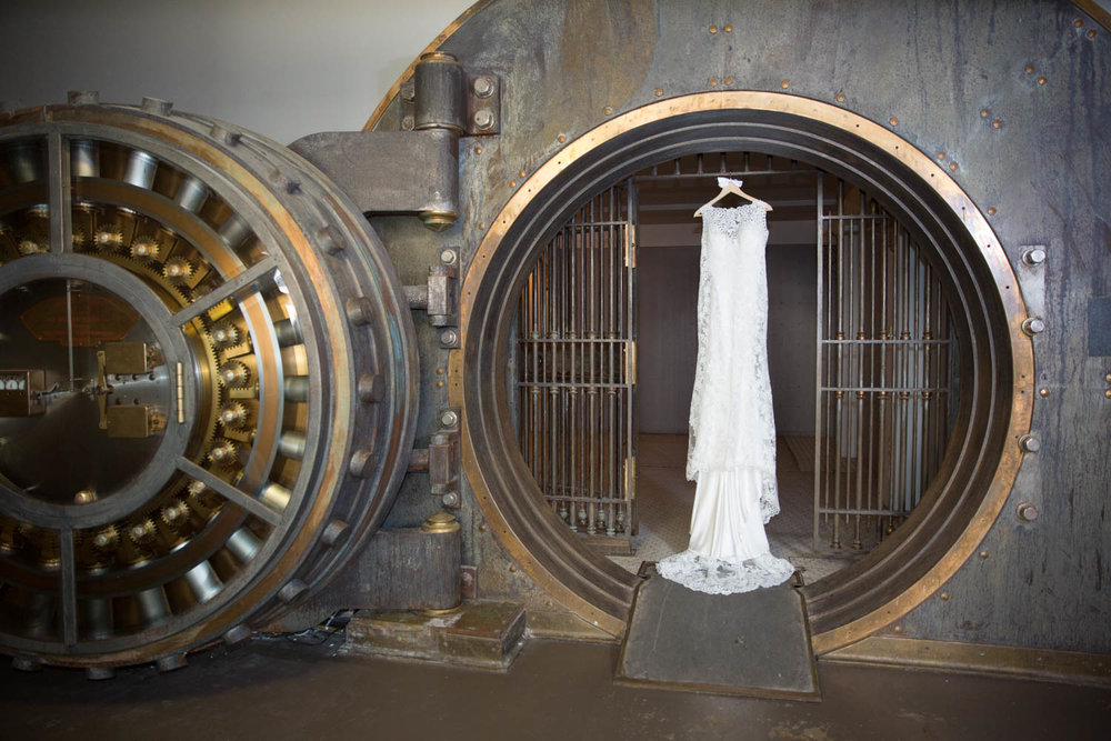 wedding dress hanging in an open bank vault