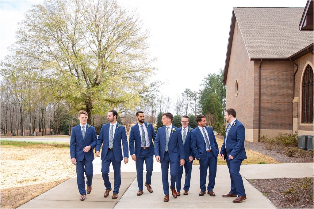 guys in blue suits posing for wedding pictures