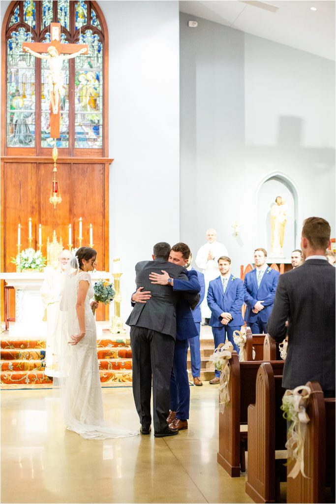 Groom hugs dad before wedding