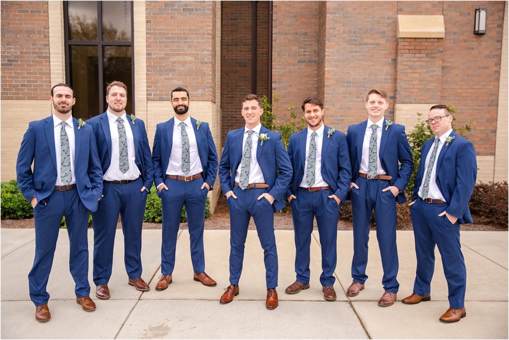 Men in blue suit pose for wedding pictures