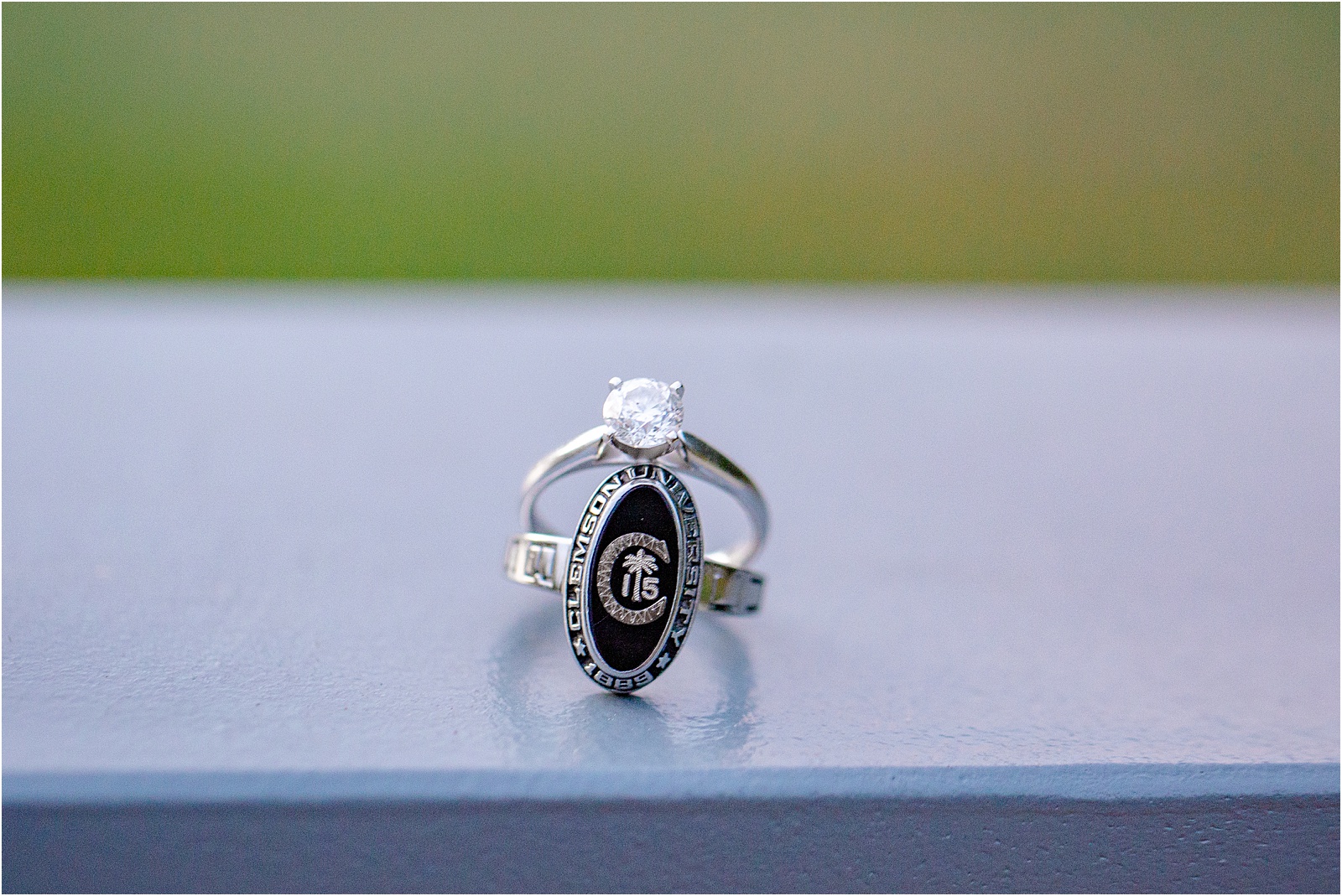 Diamond engagement ring on top of Clemson graduation ring