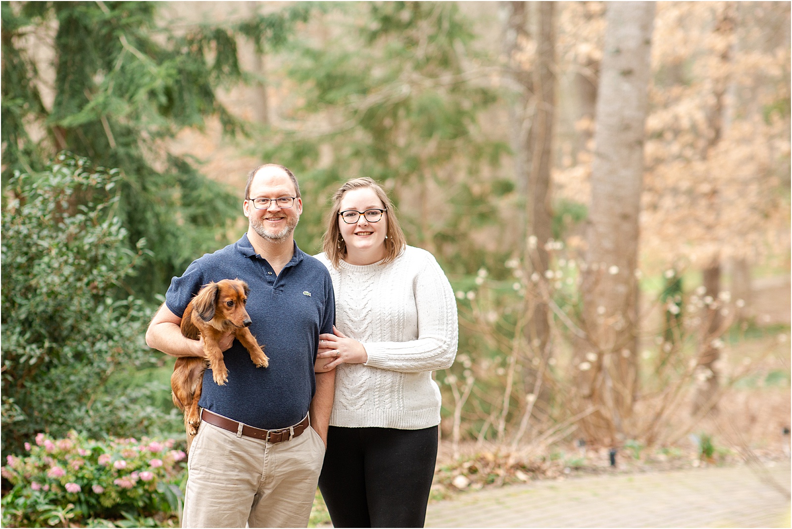 man holds brown dog for engagement session