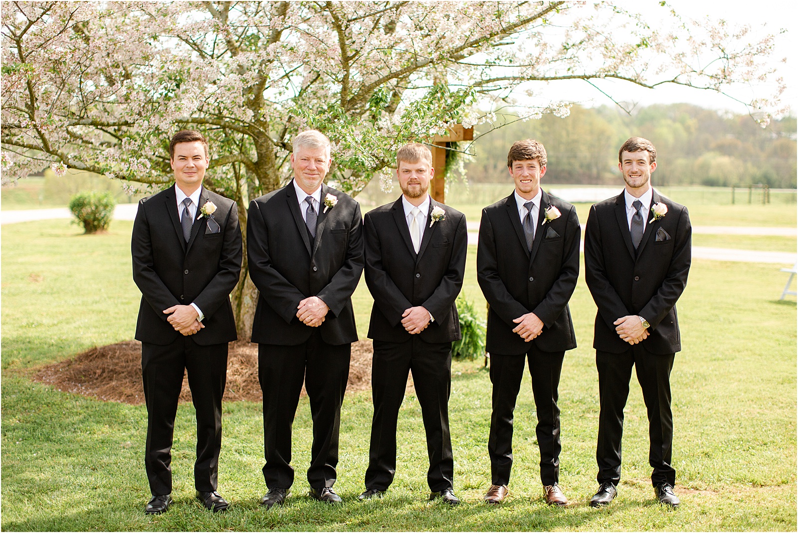 groomsmen in tuxes outside before ceremony