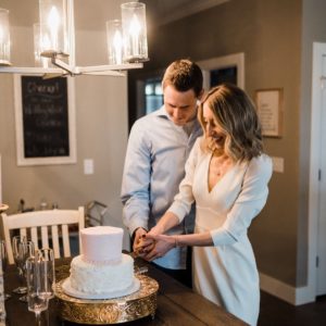 couple cutting cake after zoom wedding