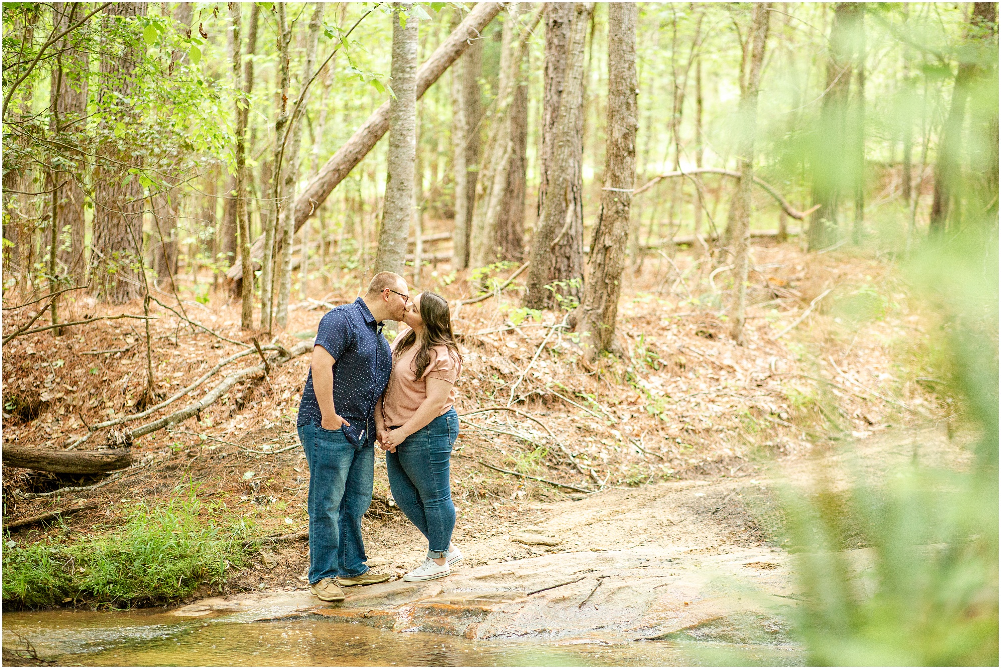 Kissing couple in the woods for photographs