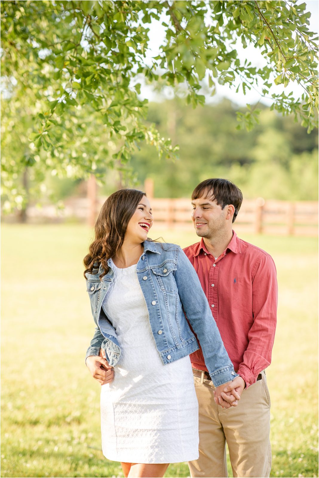 Engagement session in a field with laughing couple