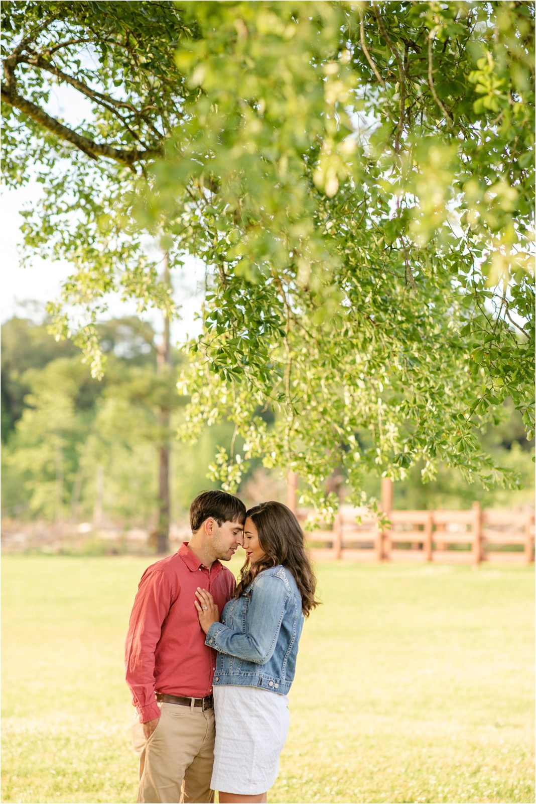 cute engaged couple hugging in a field