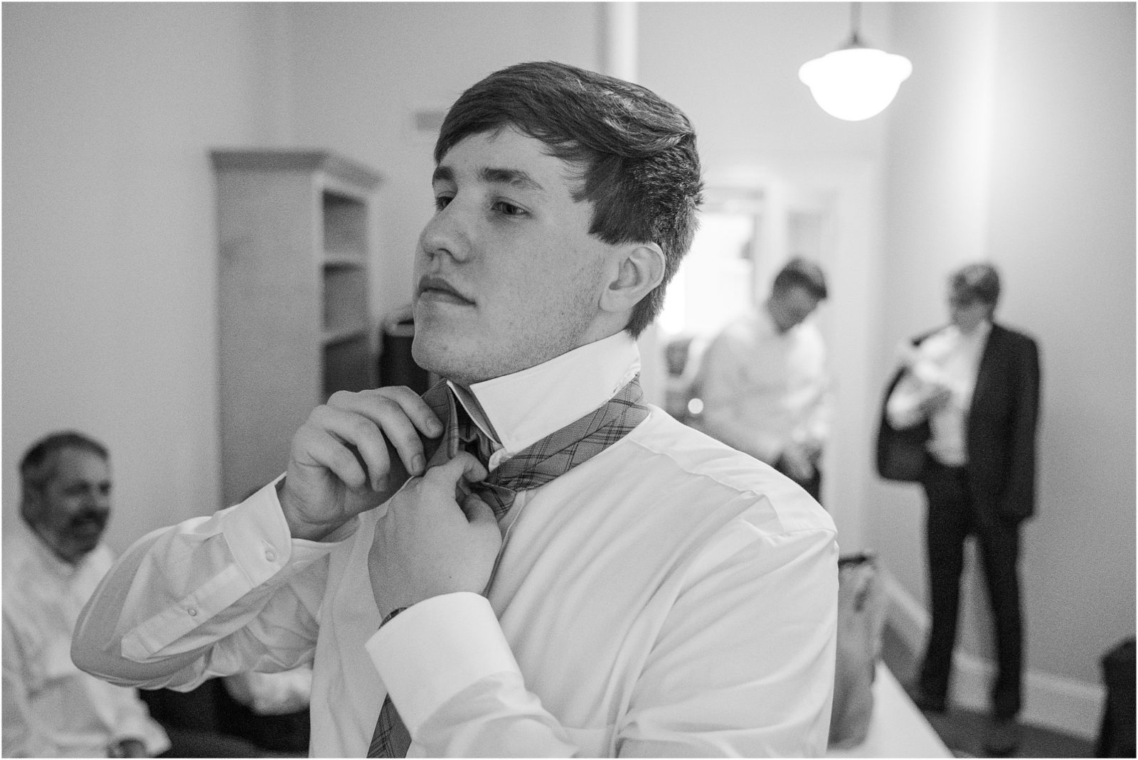 Guy putting on tie for wedding