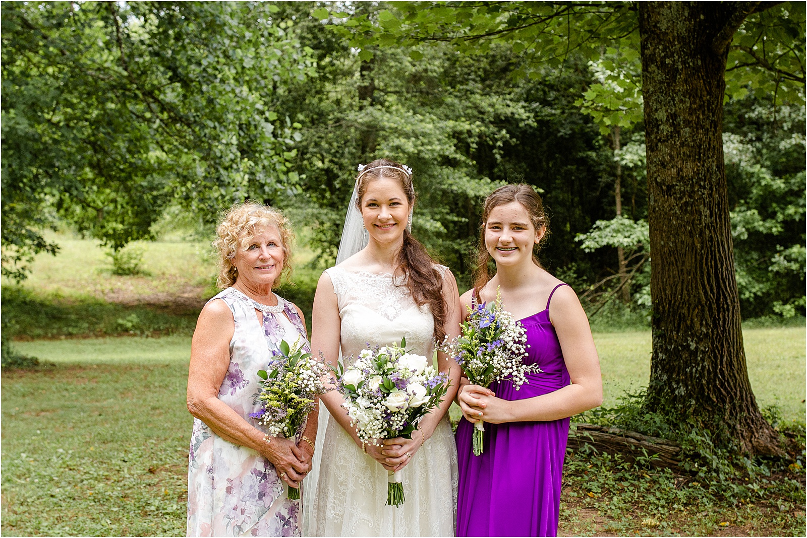 Bride in wedding dress with family in purple