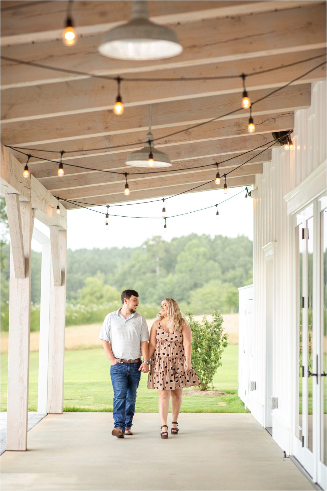 Engaged couple walking next to Heyward Manor barn
