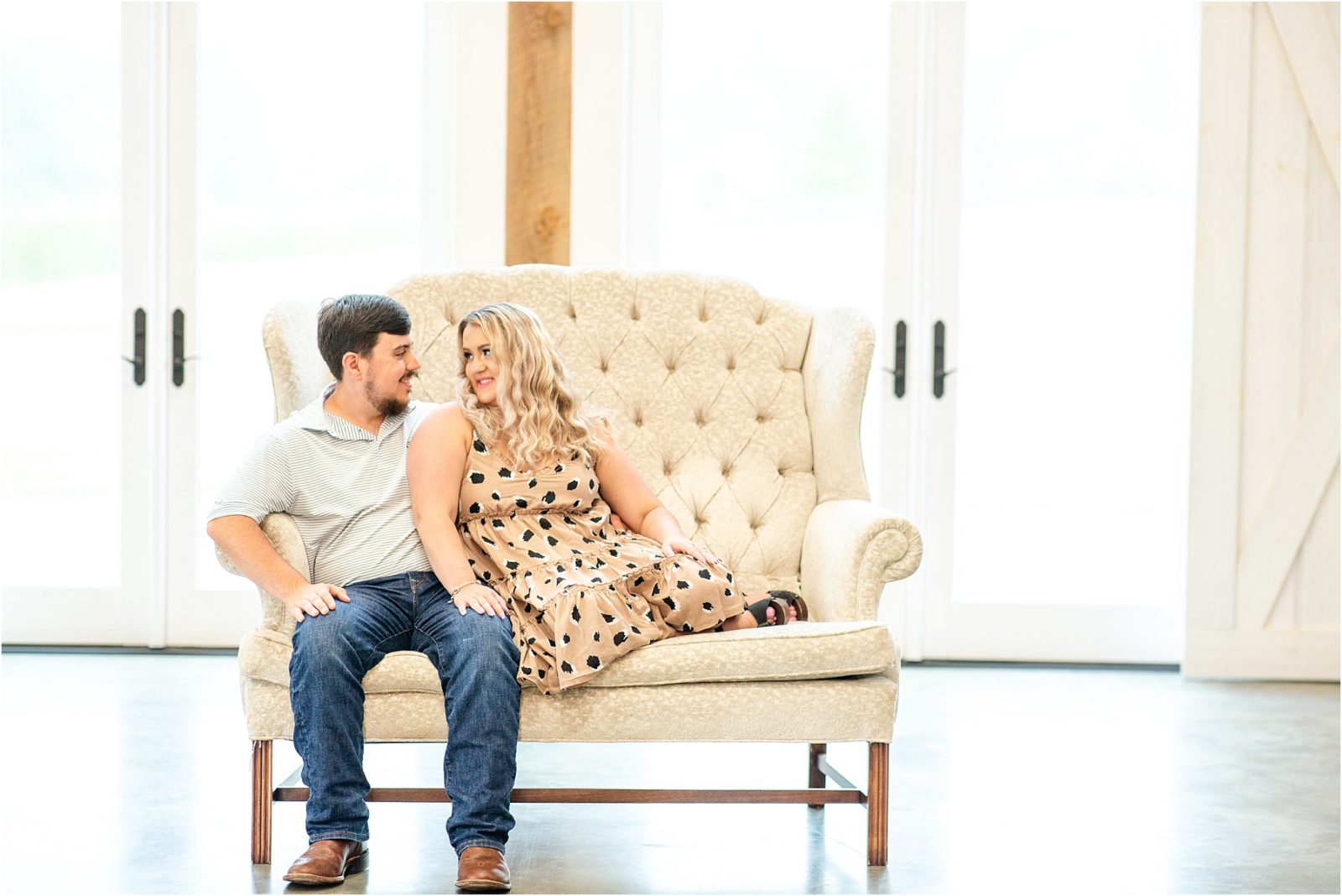 Engaged couple sitting on couch for pictures