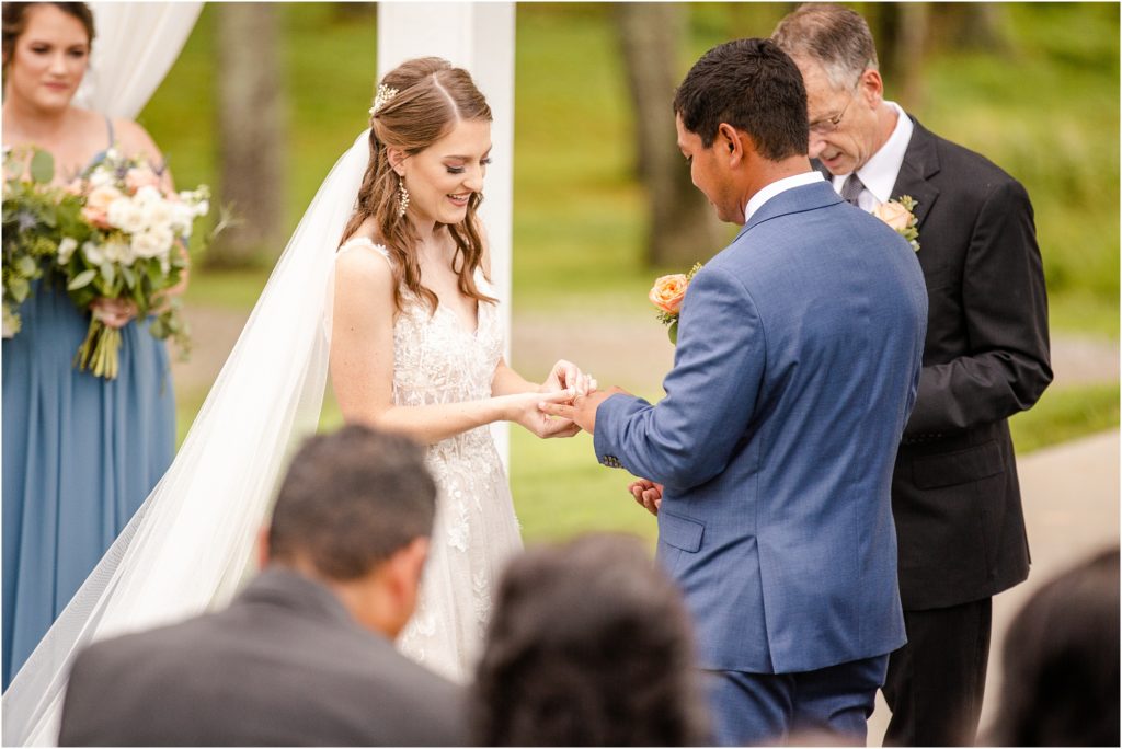 Bride puts ring on groom