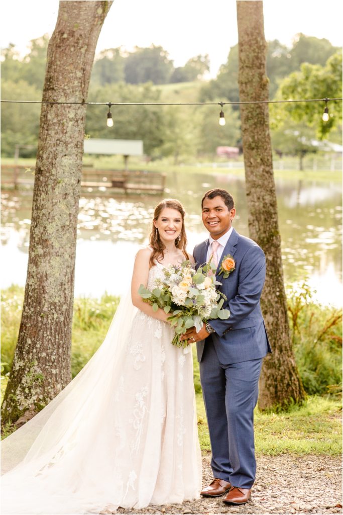 Couple holding flowers in front of pond in Travelers Rest