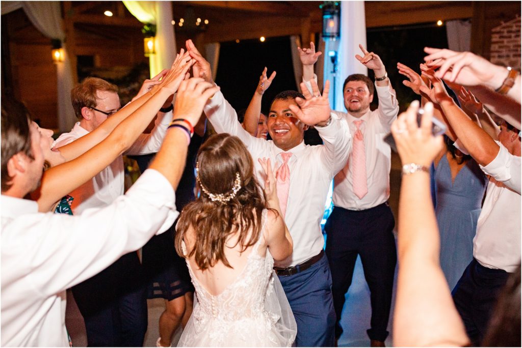 Husband dancing with bride surrounded by friends