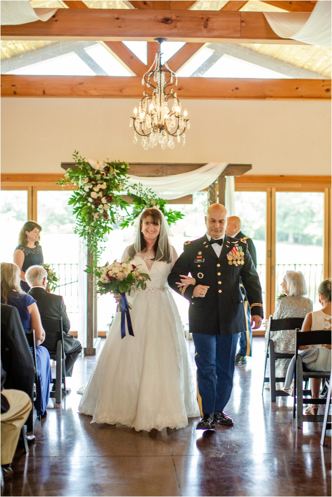 Navy man walking down wedding aisle with bride