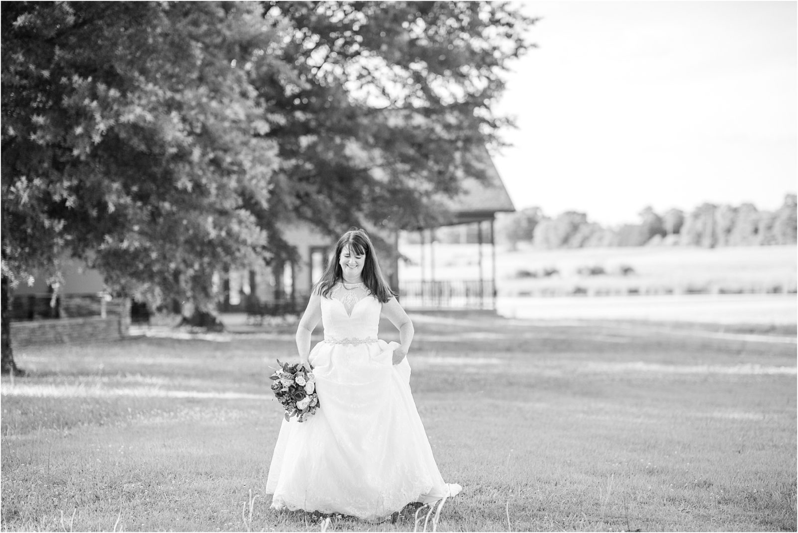 Bride holding dress up walking in Anderson SC field