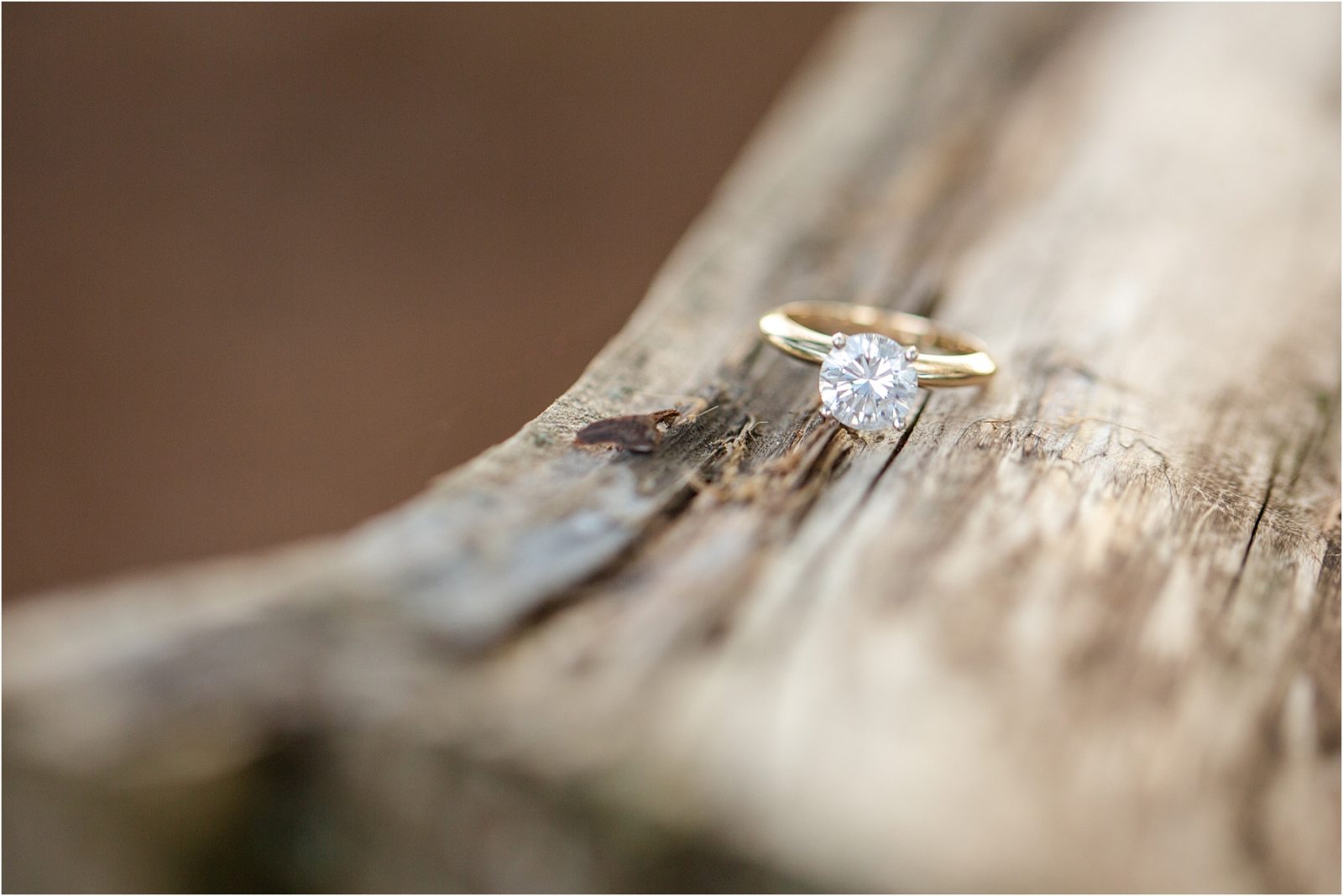 Gold diamond ring on wooden rail