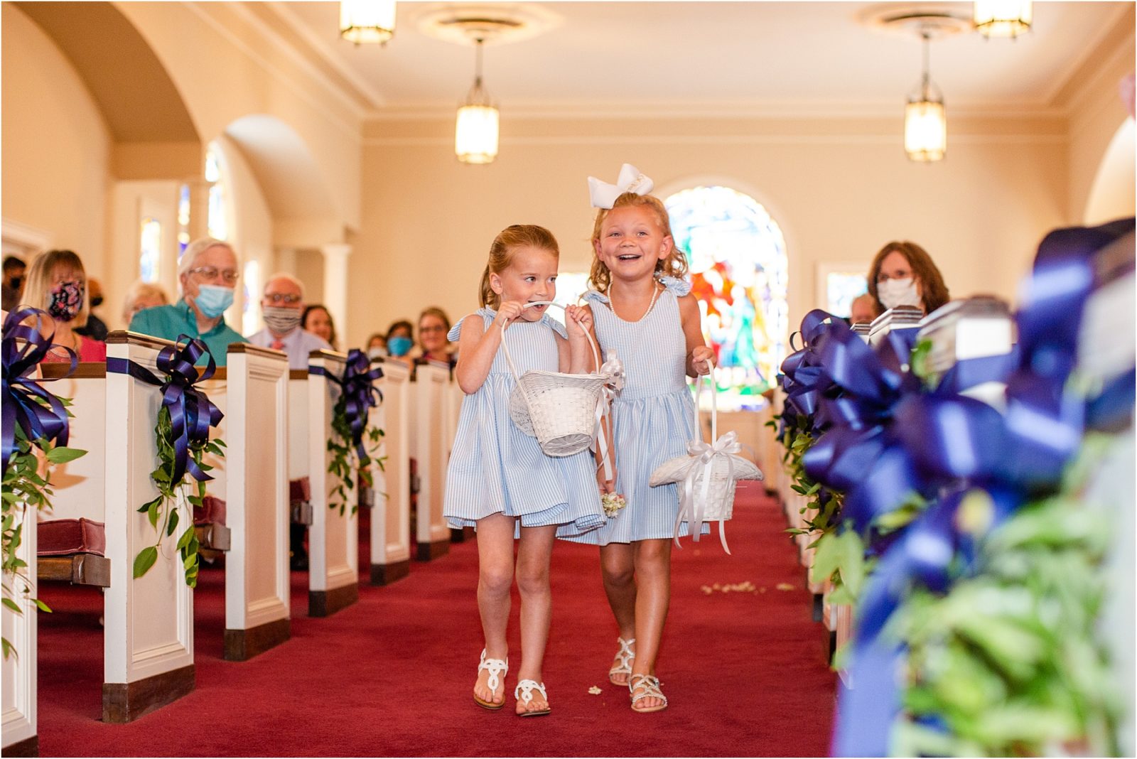flower girls walk down church aisle