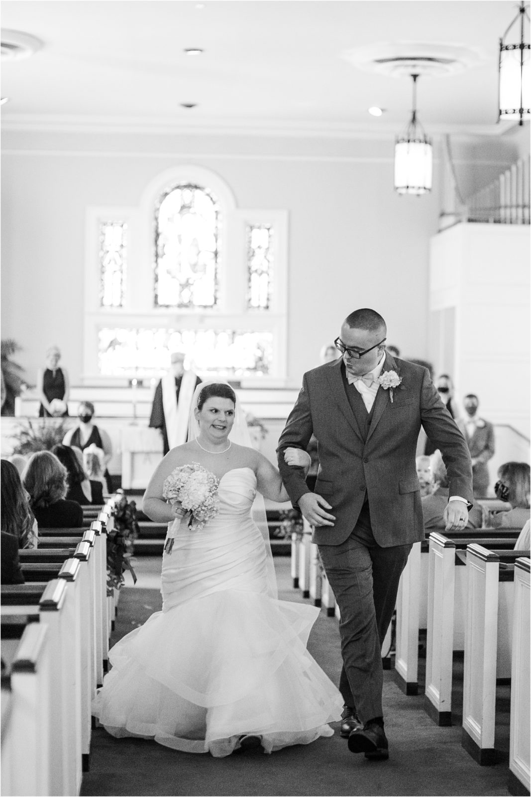 Couple walking back down church aisle after wedding ceremony