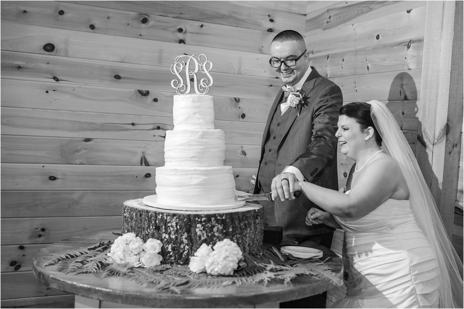Bride laughs as she cuts wedding cake