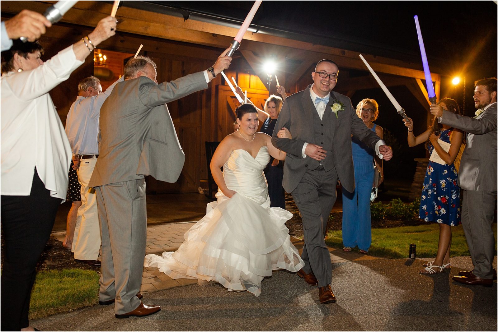 Man and woman leave wedding reception under light sabers