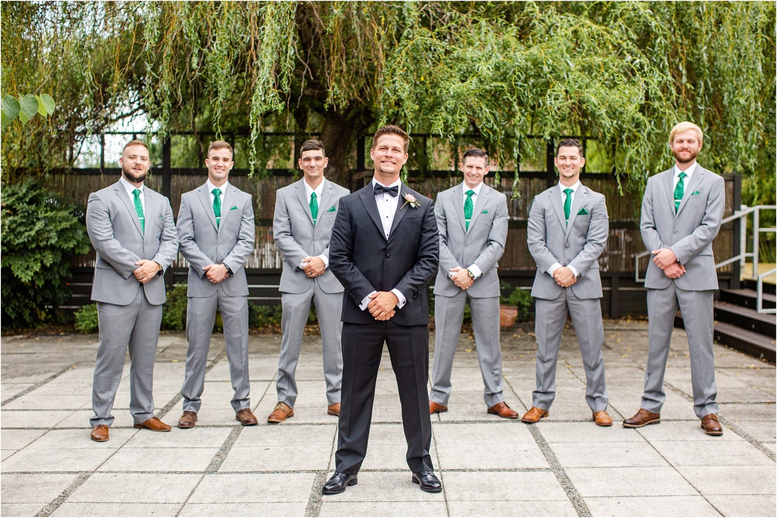 Groom in tux with groomsmen in grey suits