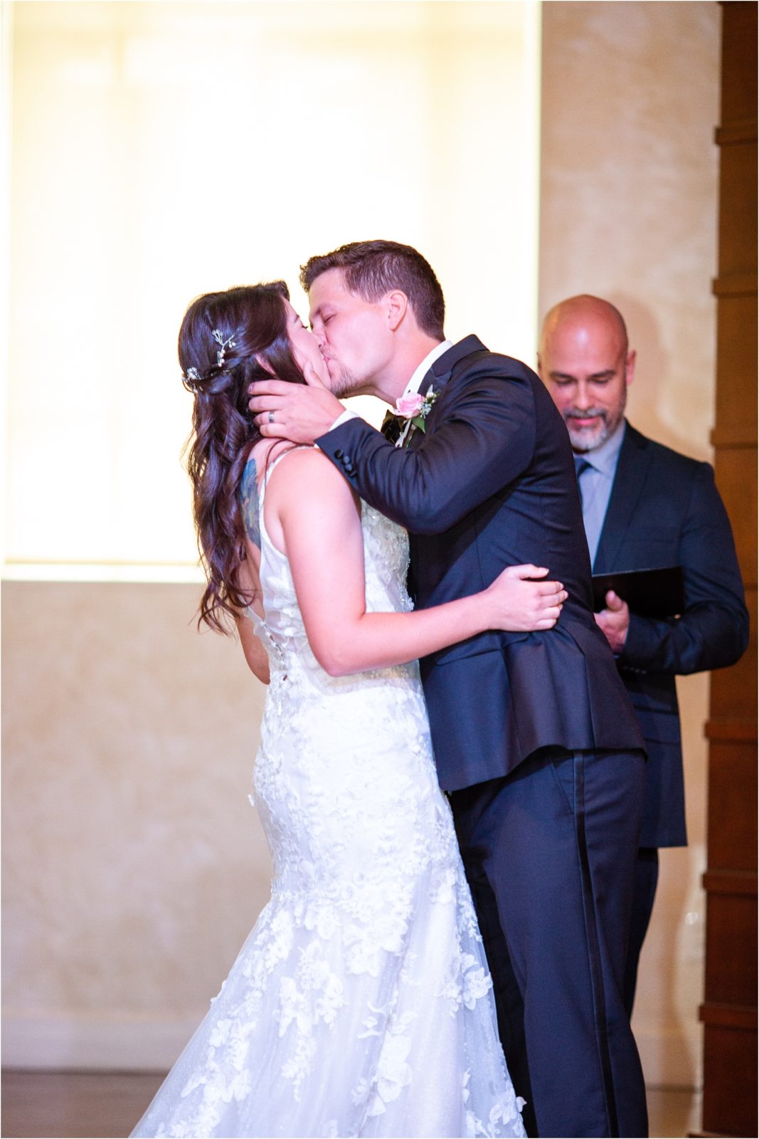Groom kisses bride during wedding ceremony