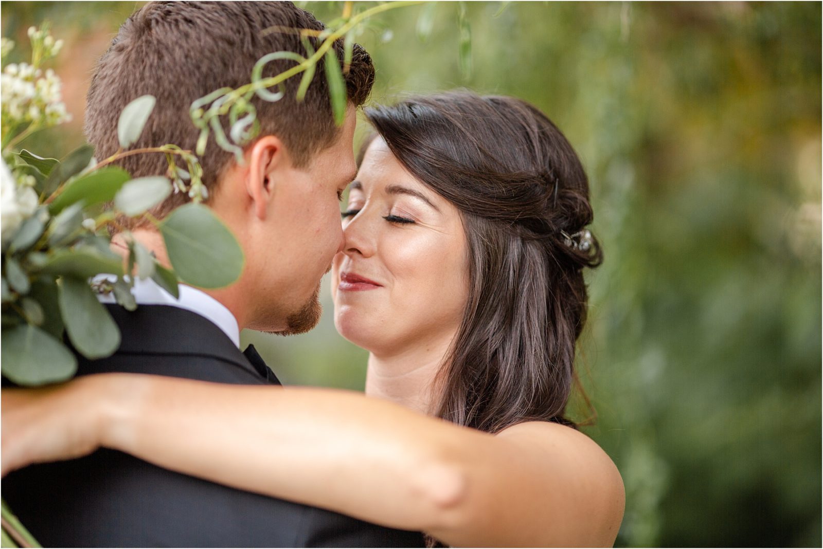 Bride smiles with eyes closed at groom
