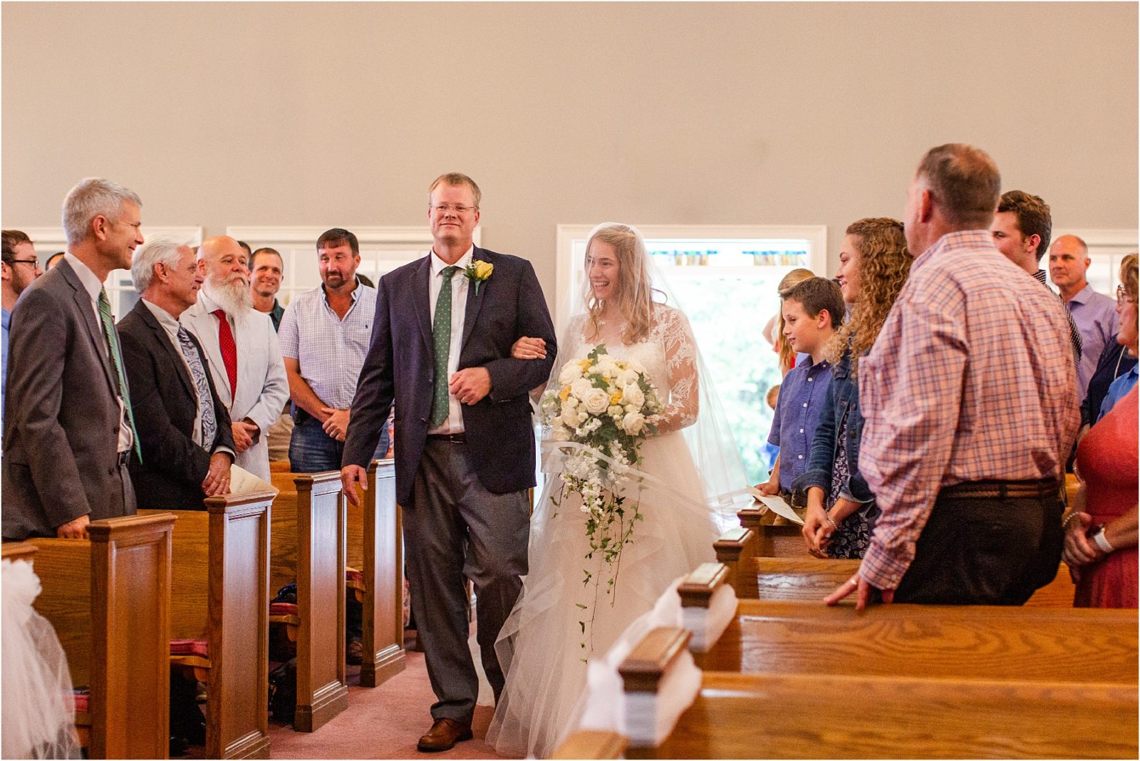Bride walking with father down church aisle in Georgia