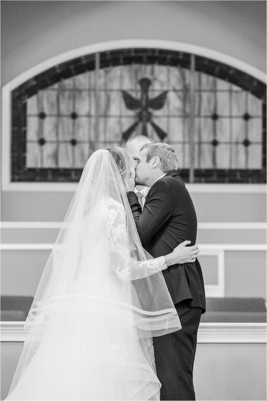 Groom and bride sharing first kiss at wedding
