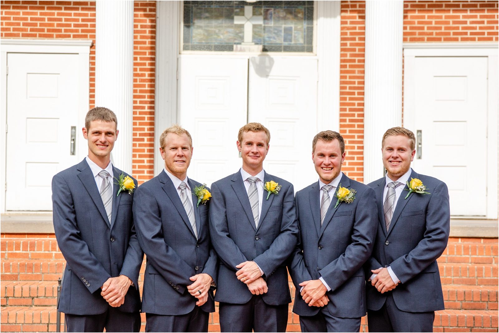 Men in navy suits taking pictures before wedding