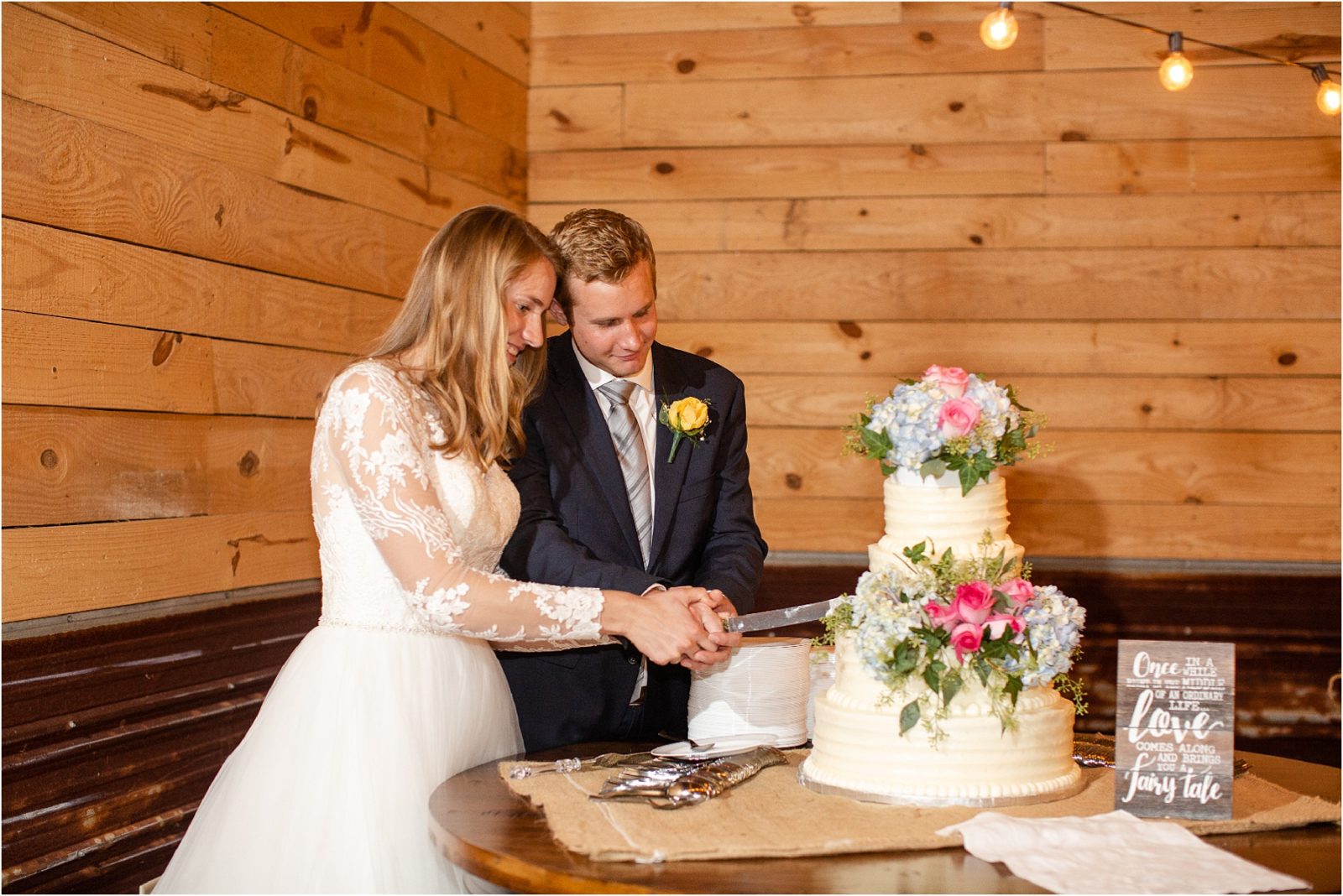 Married couple holding knife together to cut wedding cake