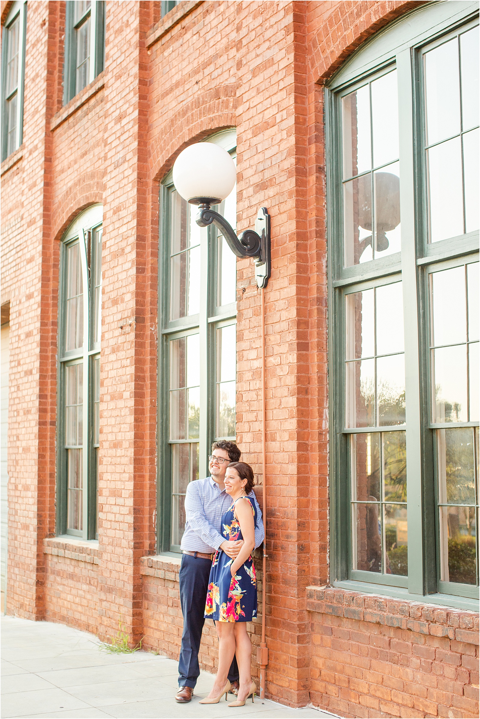 Couple hugging in front of building with large windows