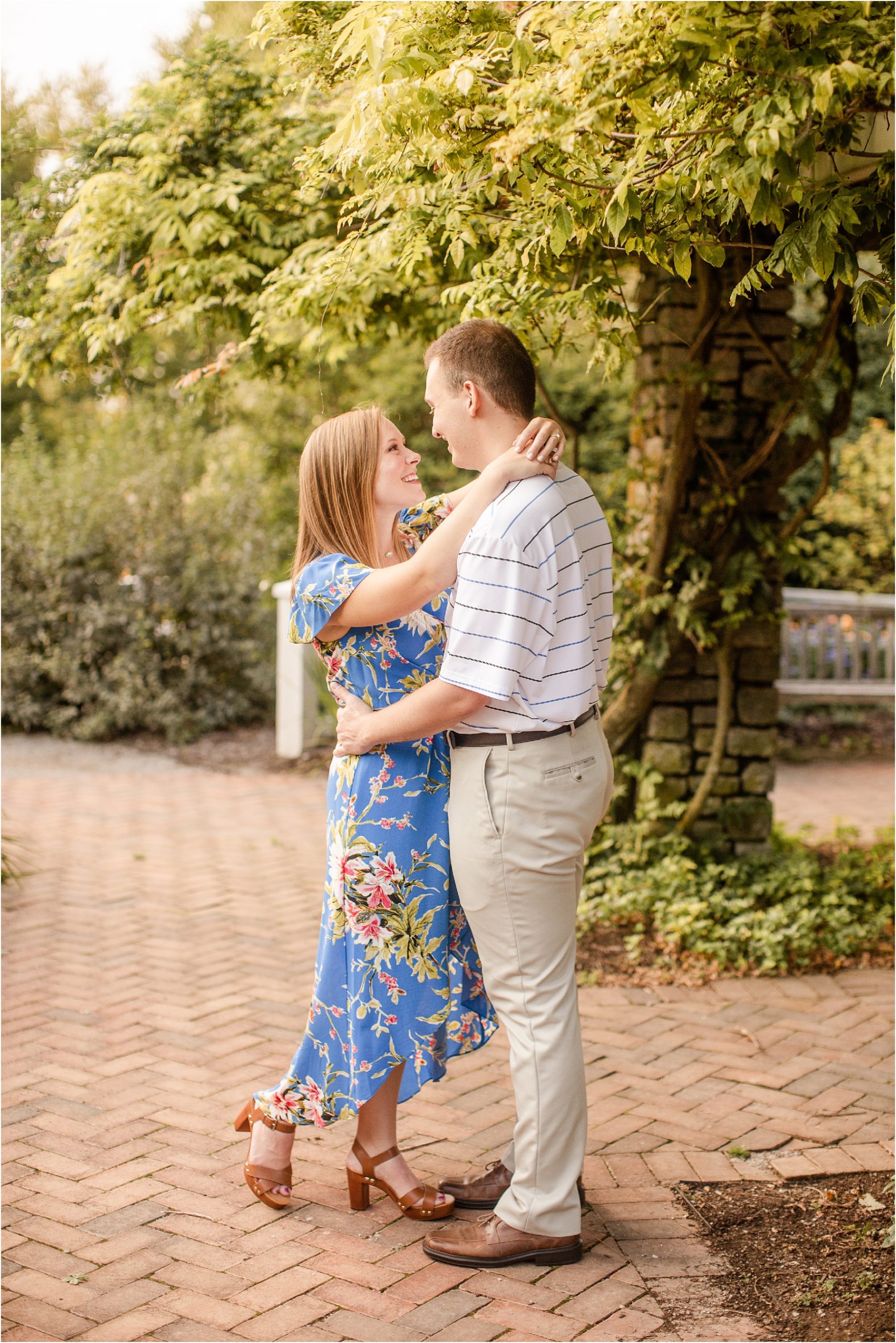 Couple with arms around each other next to ivy