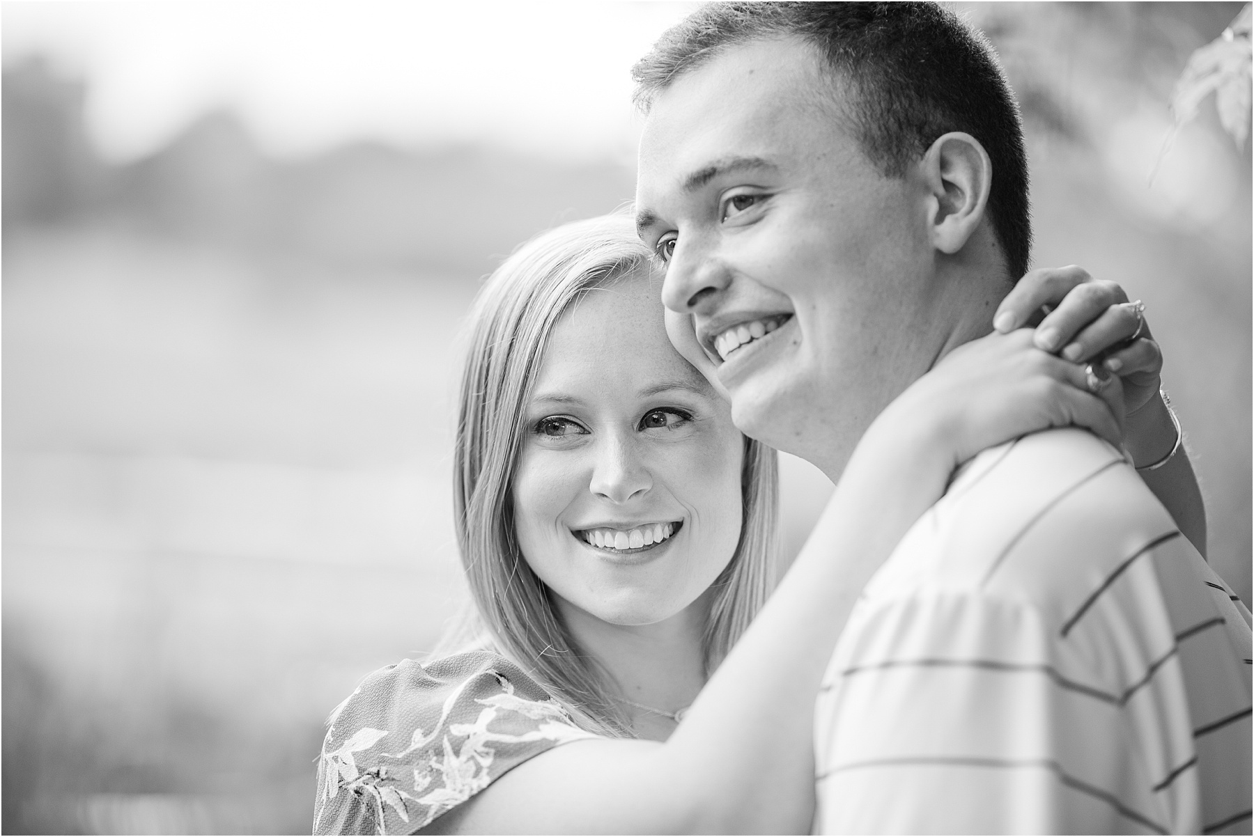 Happy couple smiling as woman has arms around his neck