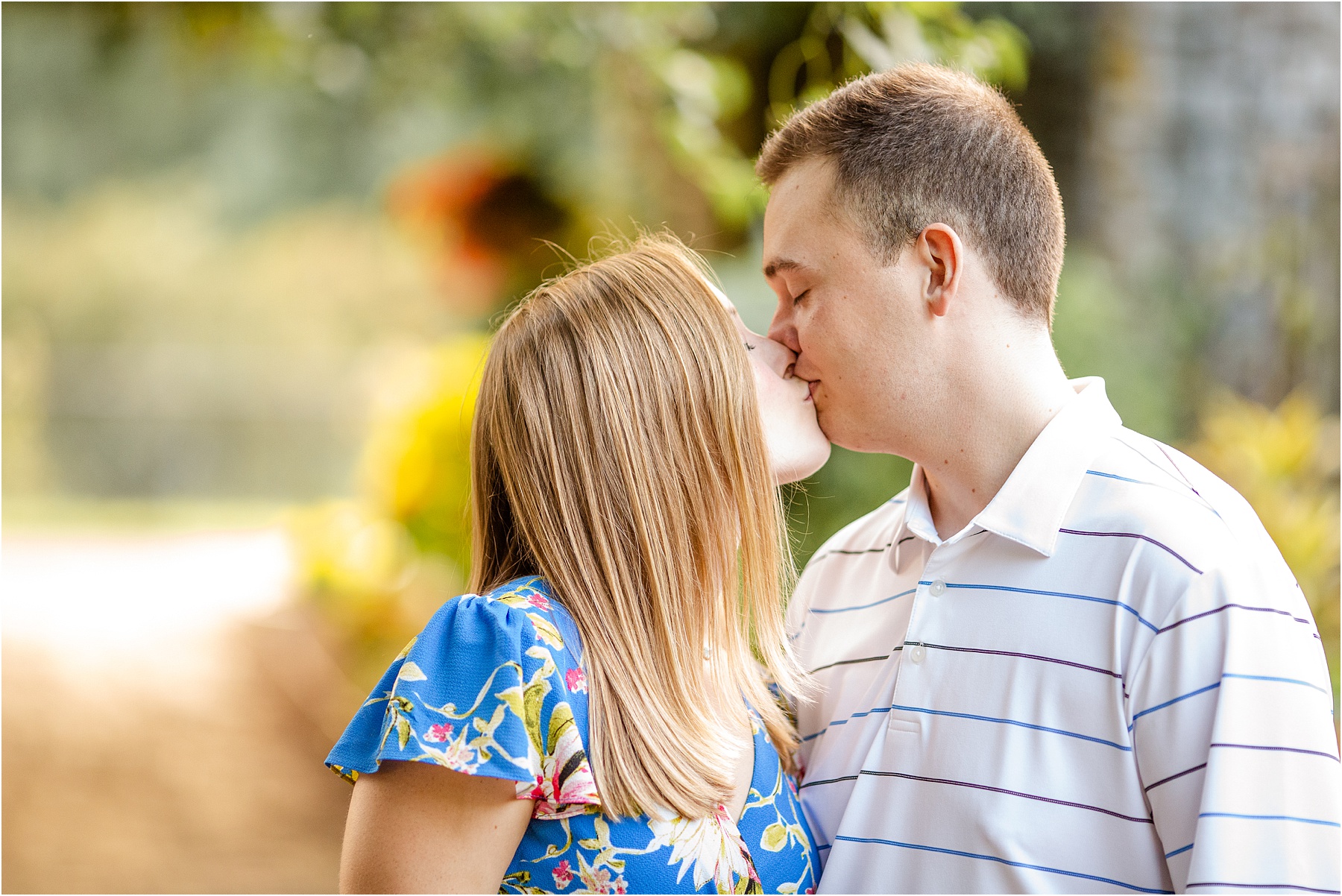 Engaged couple kisses in garden