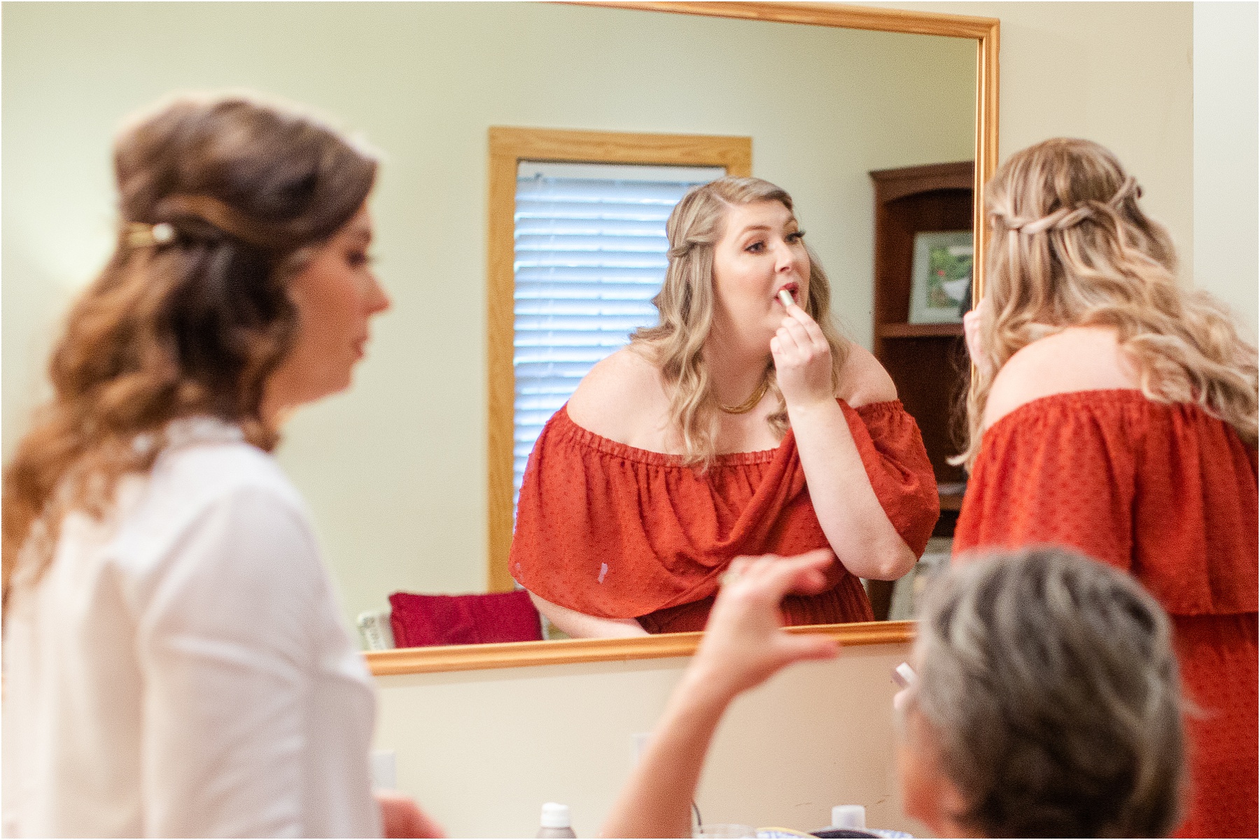 Woman putting on lipstick for wedding