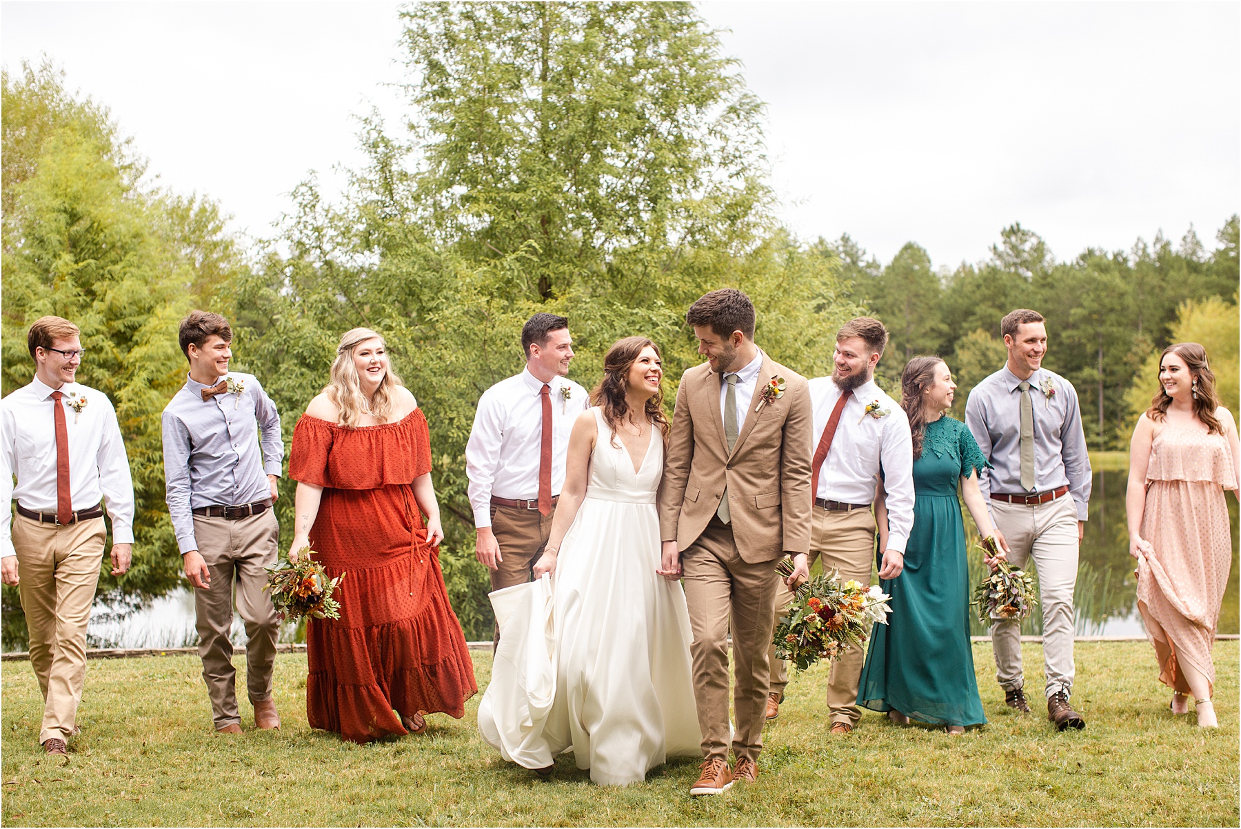 Woman in wedding dress smiles up at her groom in brown suit as they walk together