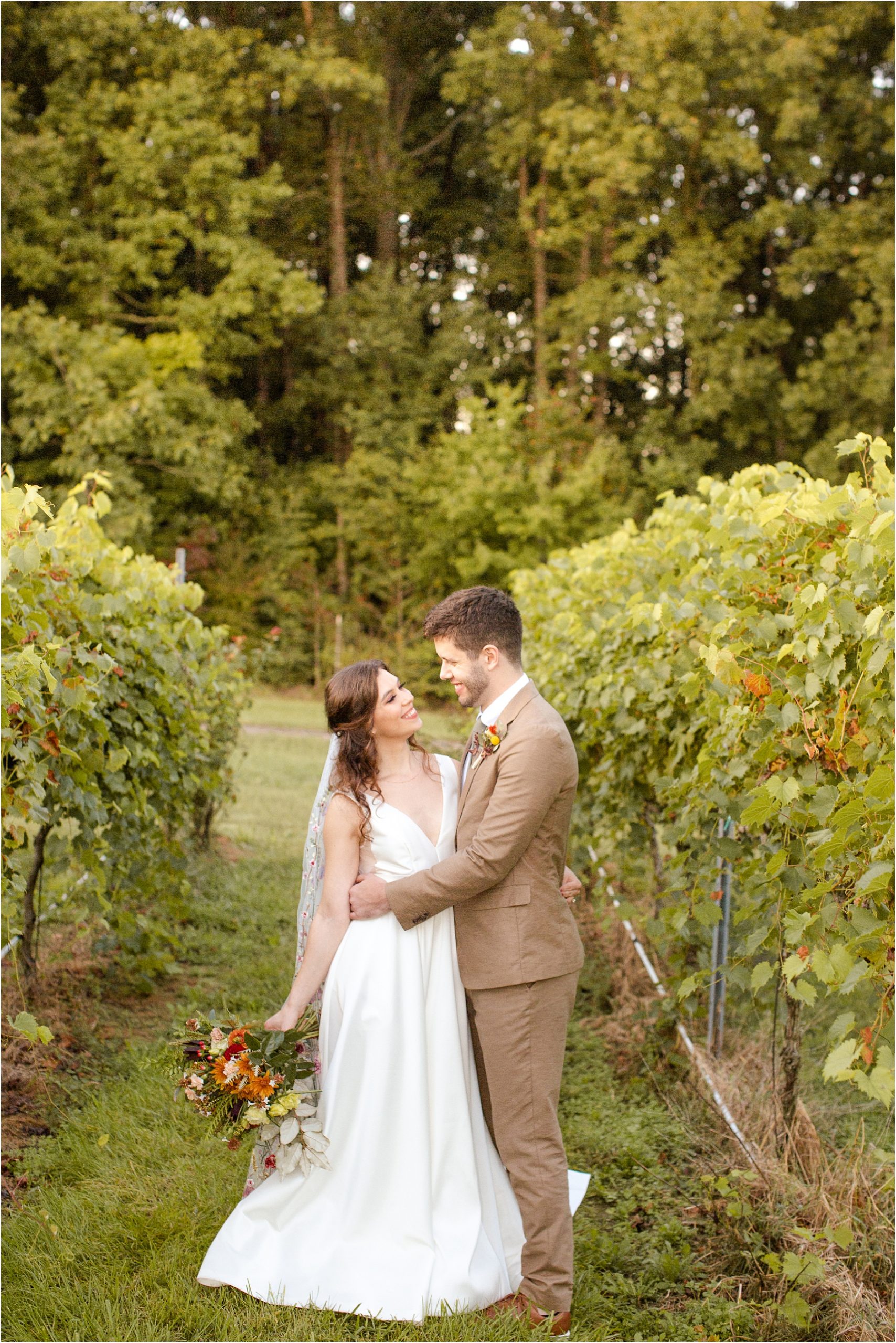 Couple hugs in a vineyard after their wedding ceremony in Greenville