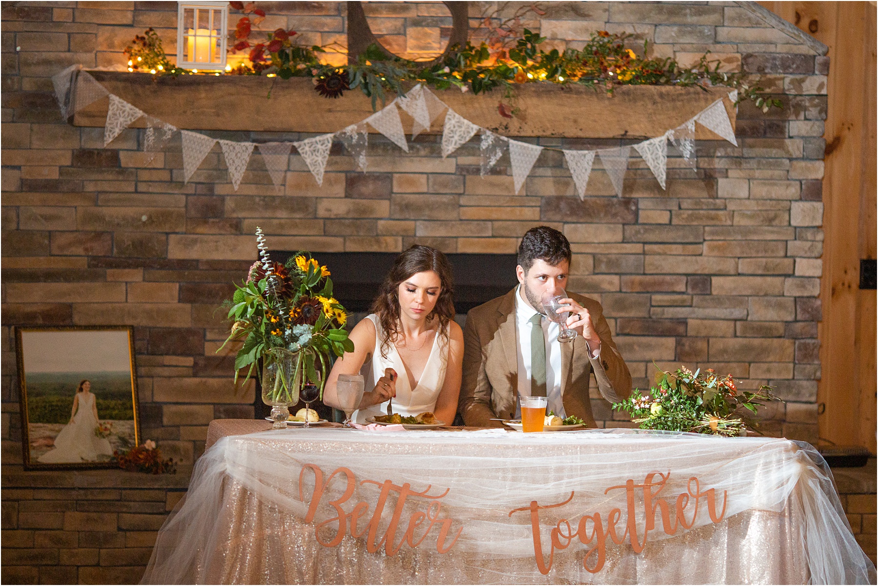 Newlyweds sitting at table in front of fireplace eating food