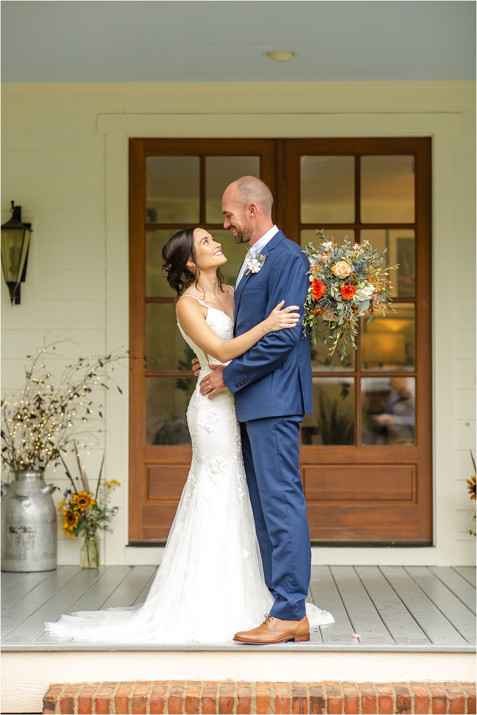 Married couple stands on a porch hugging before ceremony