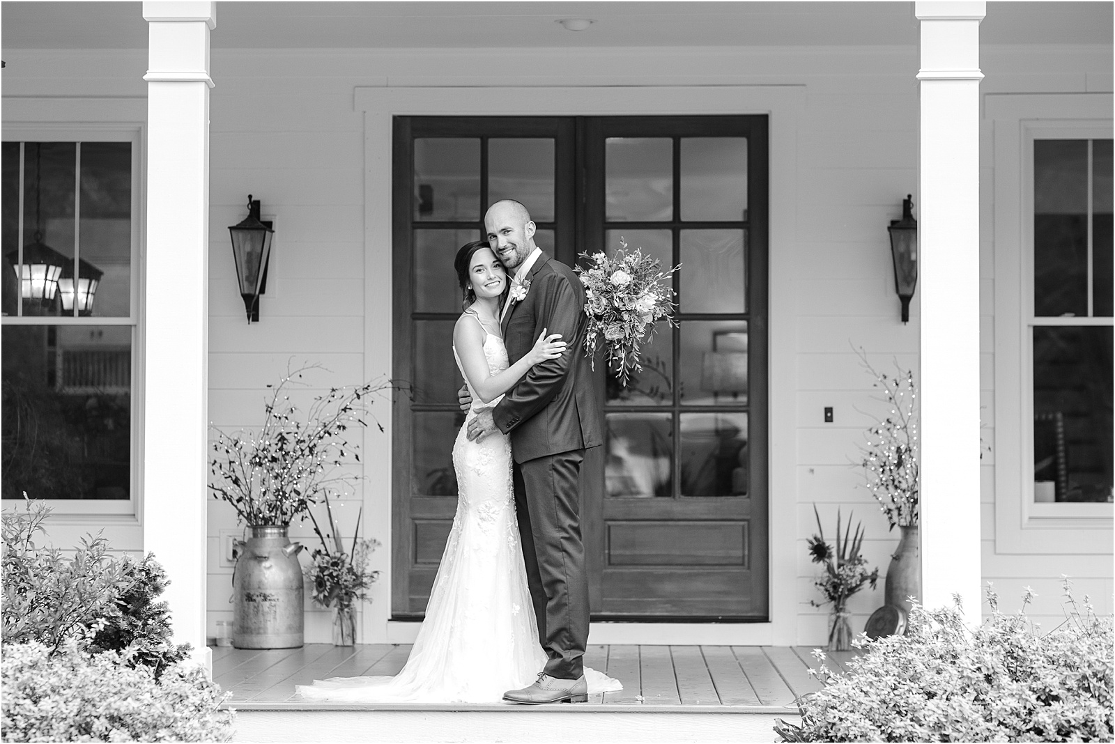 Groom with bride hugging on the porch of a house