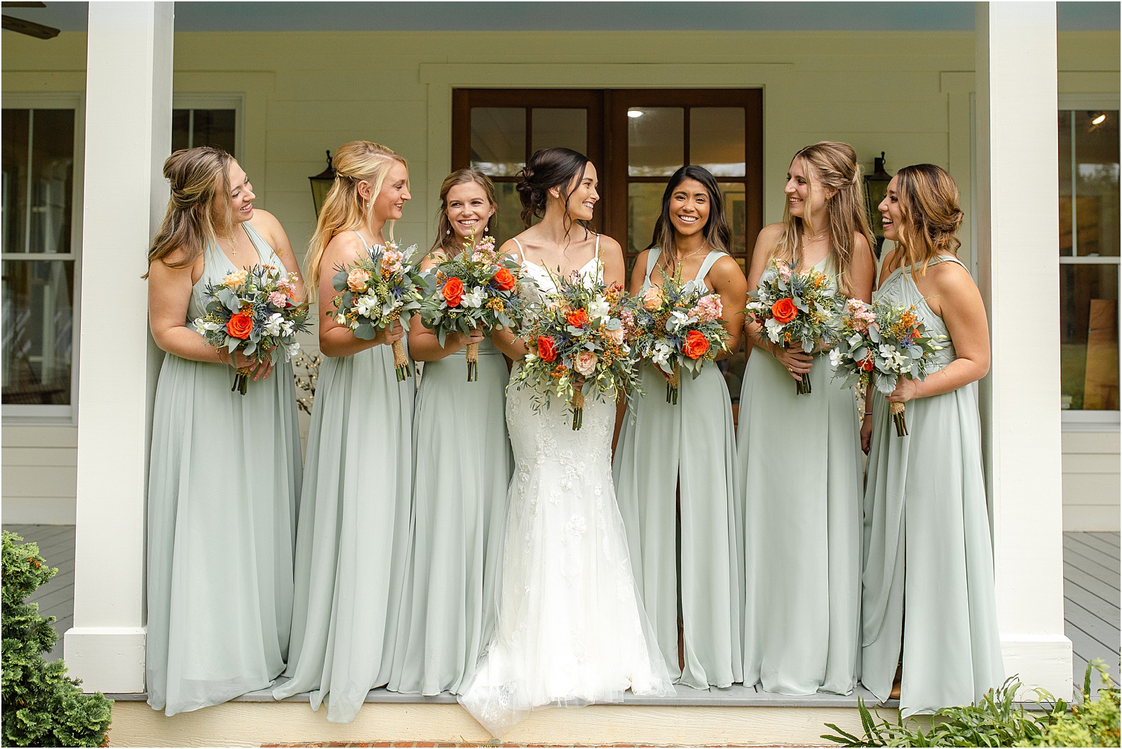 Bride standing with all of her bridesmaids on a white porch in Anderson, SC