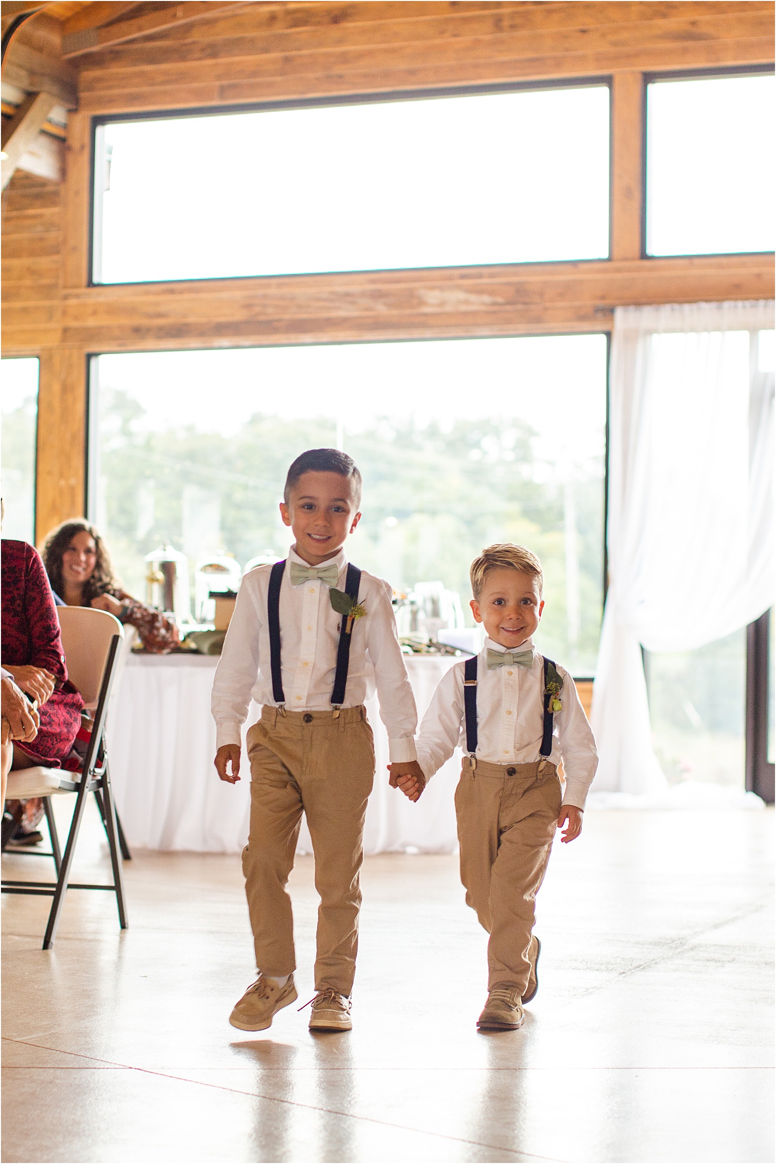 two young boys in wedding clothes holding hands