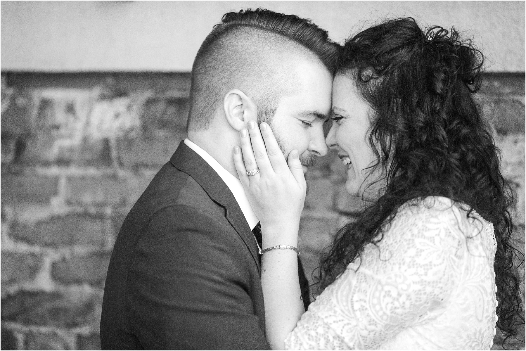 Bride touches grooms face while smiling