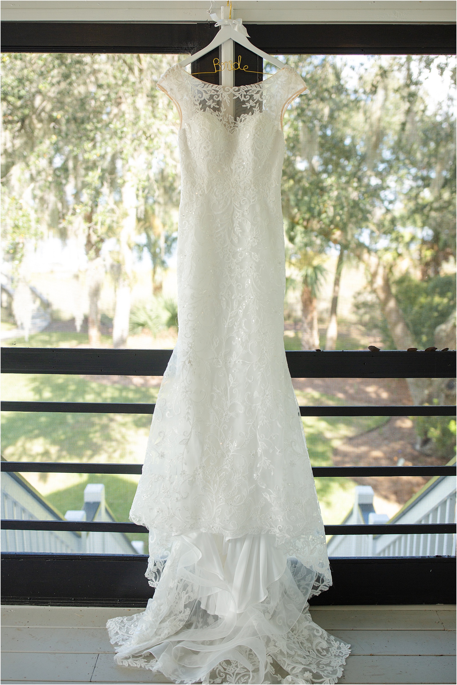 bridal gown hanging on a porch by the water