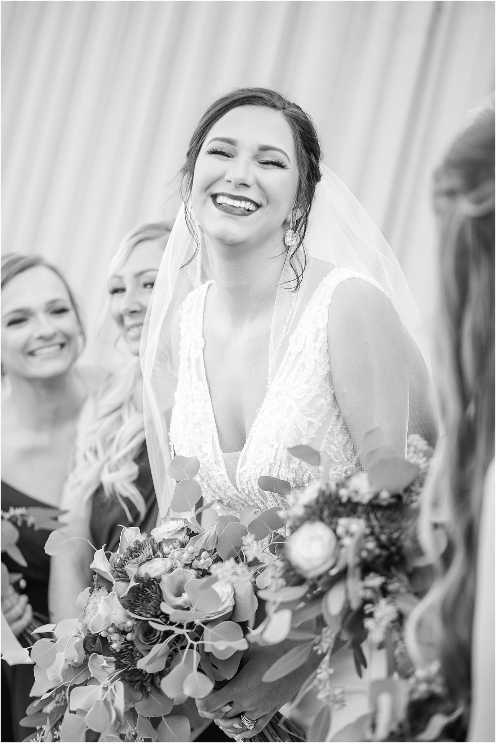 bride in wedding dress laughs with her friends before wedding ceremony